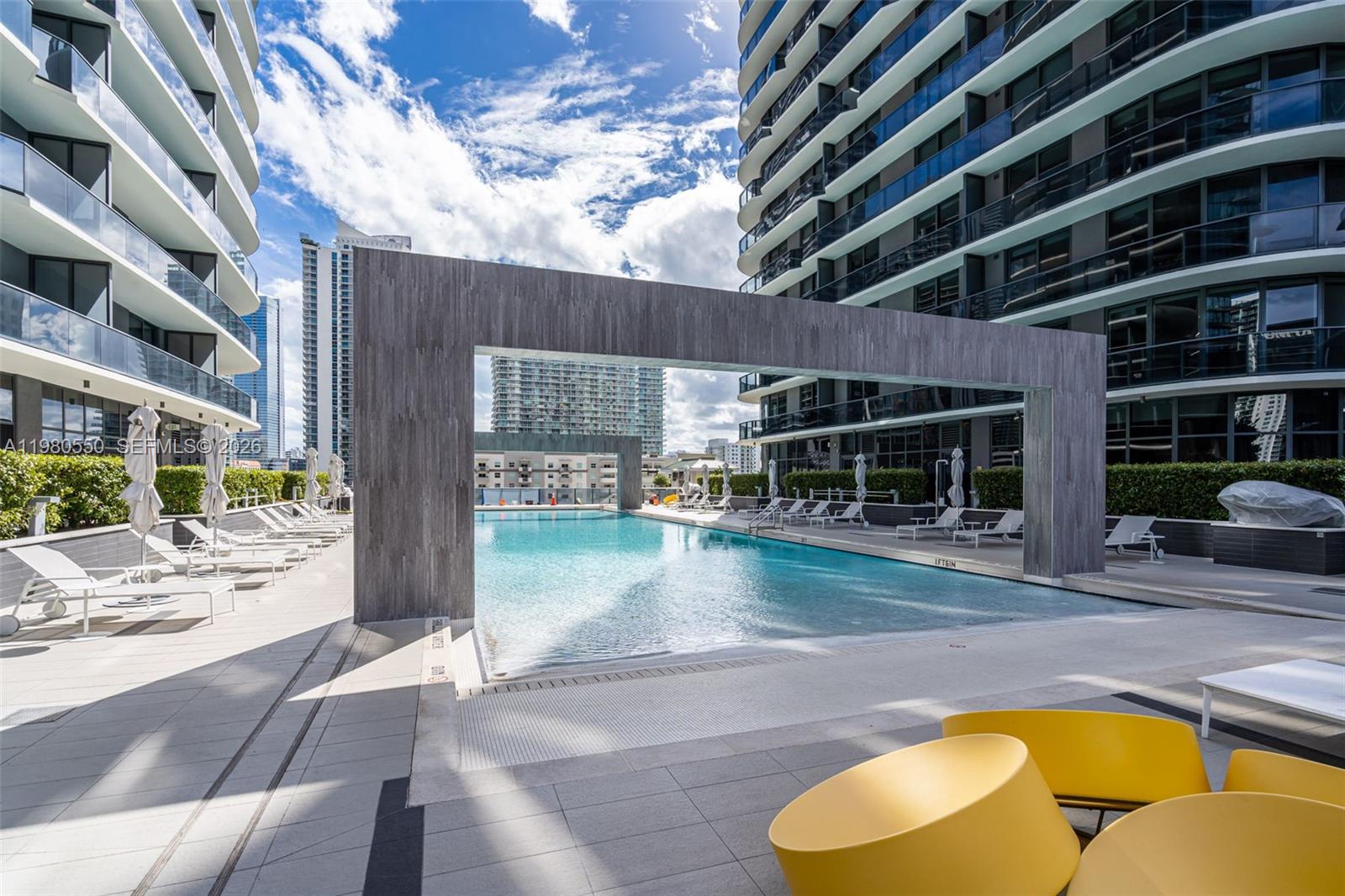 Aerial view of two modern high-rise residential towers featuring rooftop pools and balconies — 55 SW 9th St # 1109, Miami FL 33130, MIAMI, FL