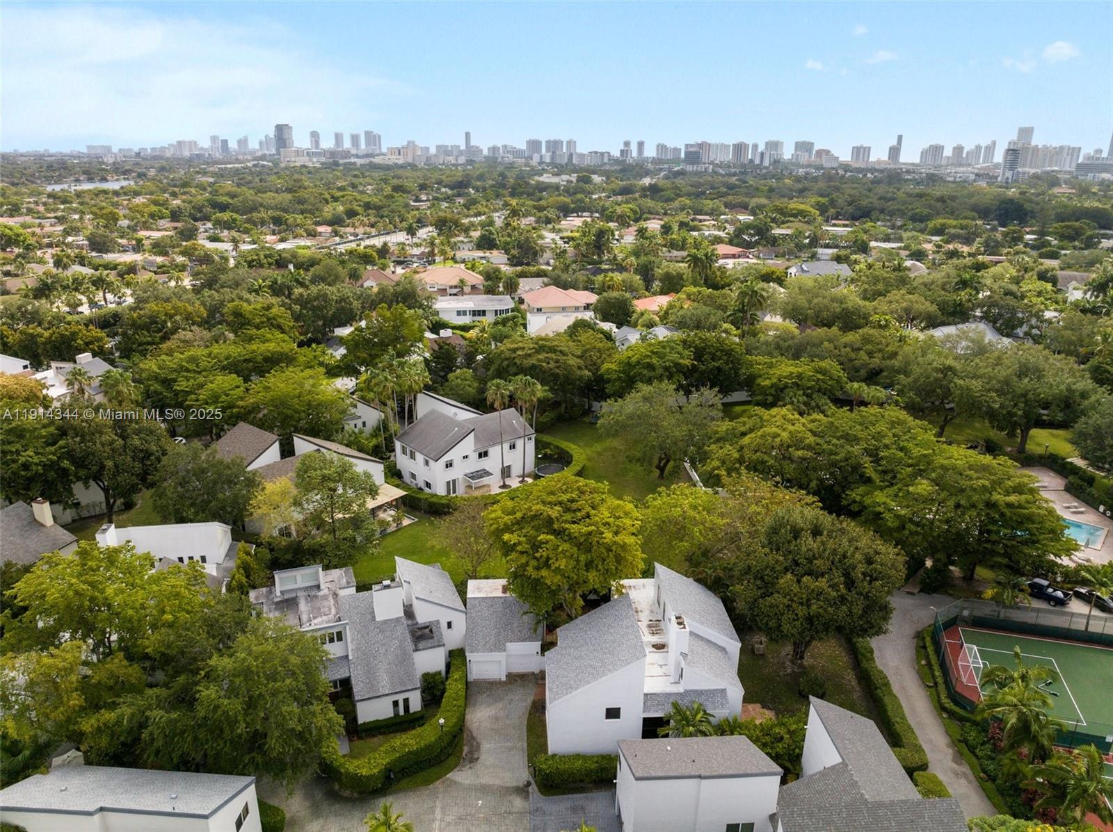 An aerial view shows several white houses with gray roofs surrounded by lush green trees — 20215 W Oak Haven Cir, Miami FL 33179, MIAMI, FL