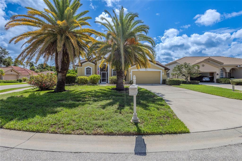 A single-story house with a two-car garage, palm trees, and a mailbox in the yard — 4092 HEARTHSTONE DRIVE, SARASOTA, FL