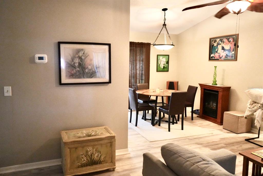A dining area with a round table and chairs sits adjacent to a living room — 10046 CHARLEMONT AVENUE, ENGLEWOOD, FL