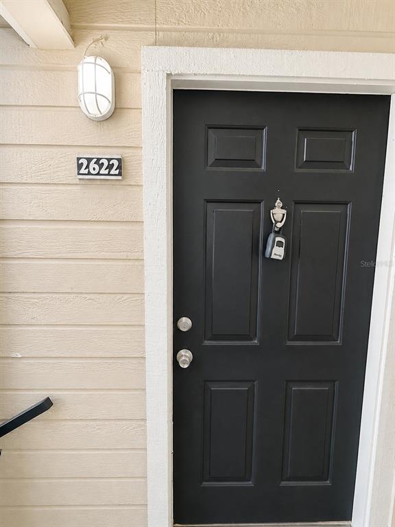 A black front door with a lockbox and house number 2622 on beige siding — 1033 S HIAWASSEE ROAD UNIT 2622, ORLANDO, FL