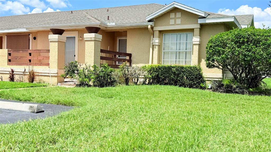 The exterior of a tan, single-story house features a front porch and a green lawn — 3101 TADPOLE COURT, KISSIMMEE, FL