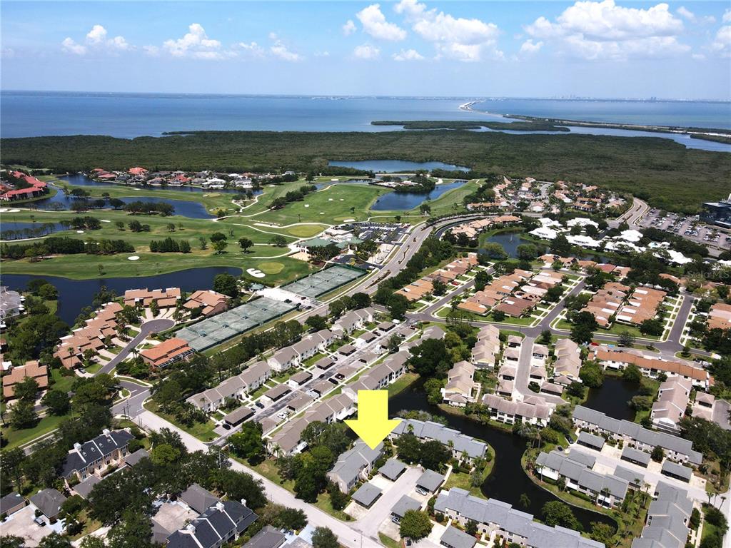 An aerial view shows a residential neighborhood with a yellow arrow pointing to a townhouse — 2480 PELICAN COURT UNIT 102R, CLEARWATER, FL