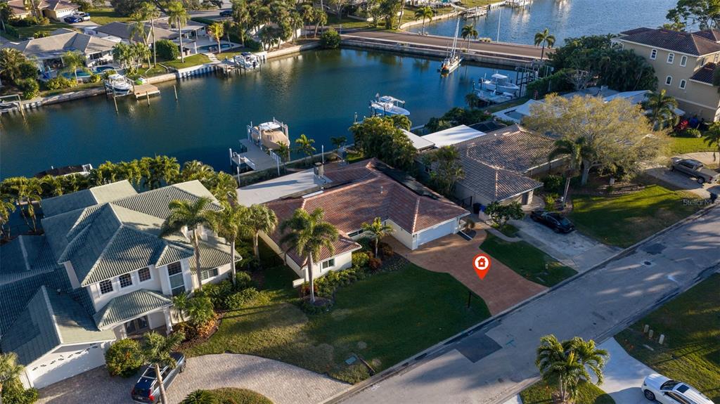 An aerial view shows a single-story house with a tiled roof and a waterfront dock — 2024 MASSACHUSETTS AVENUE NE, ST PETERSBURG, FL