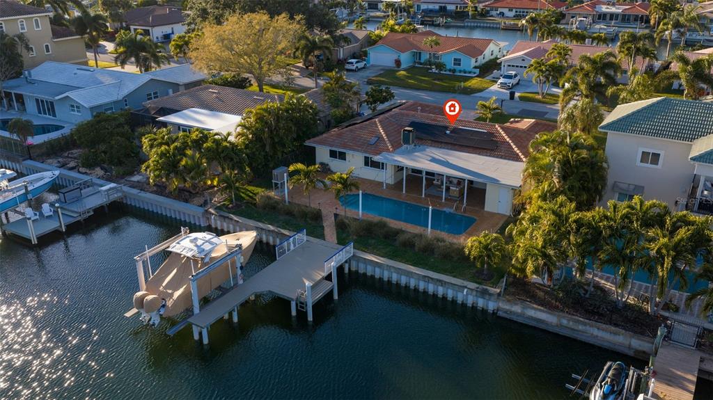 An aerial view of a waterfront house with a pool, dock, and boat lift — 2024 MASSACHUSETTS AVENUE NE, ST PETERSBURG, FL