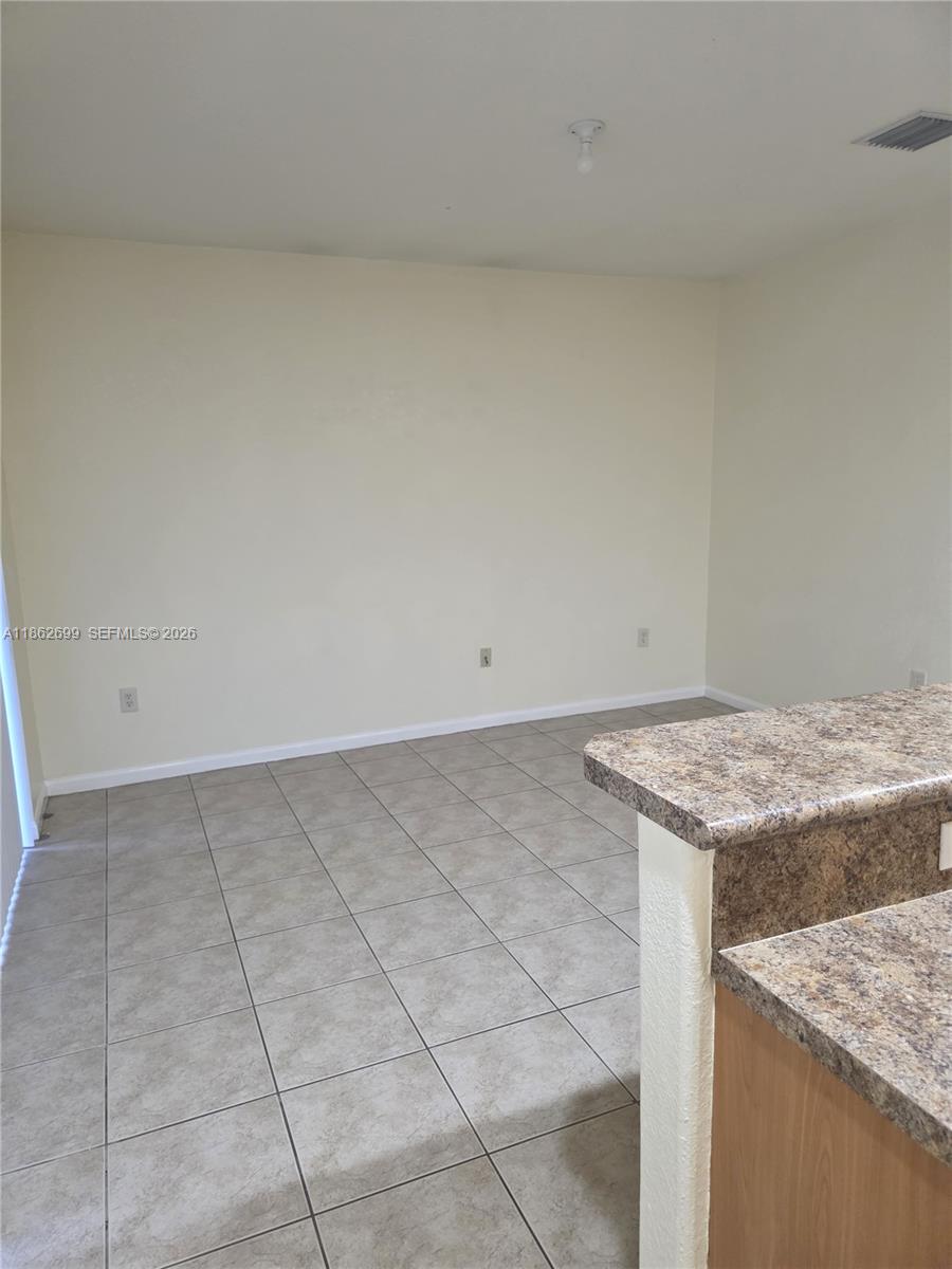 This room features beige walls, light-colored tile flooring, and a kitchen counter in the foreground — 2584 SW 84th Ter # 101, Miramar FL 33025, MIRAMAR, FL