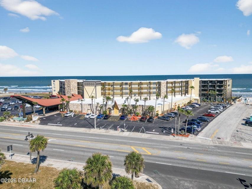 An aerial view shows a multi-story beachfront hotel with a large parking lot — 2301 S ATLANTIC AVENUE UNIT 438, DAYTONA BEACH, FL