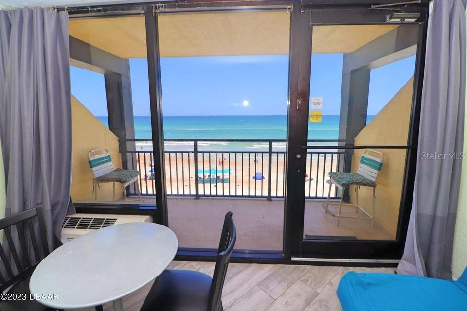 A view from a room looking out through a sliding glass door onto a balcony — 2301 S ATLANTIC AVENUE UNIT 438, DAYTONA BEACH, FL
