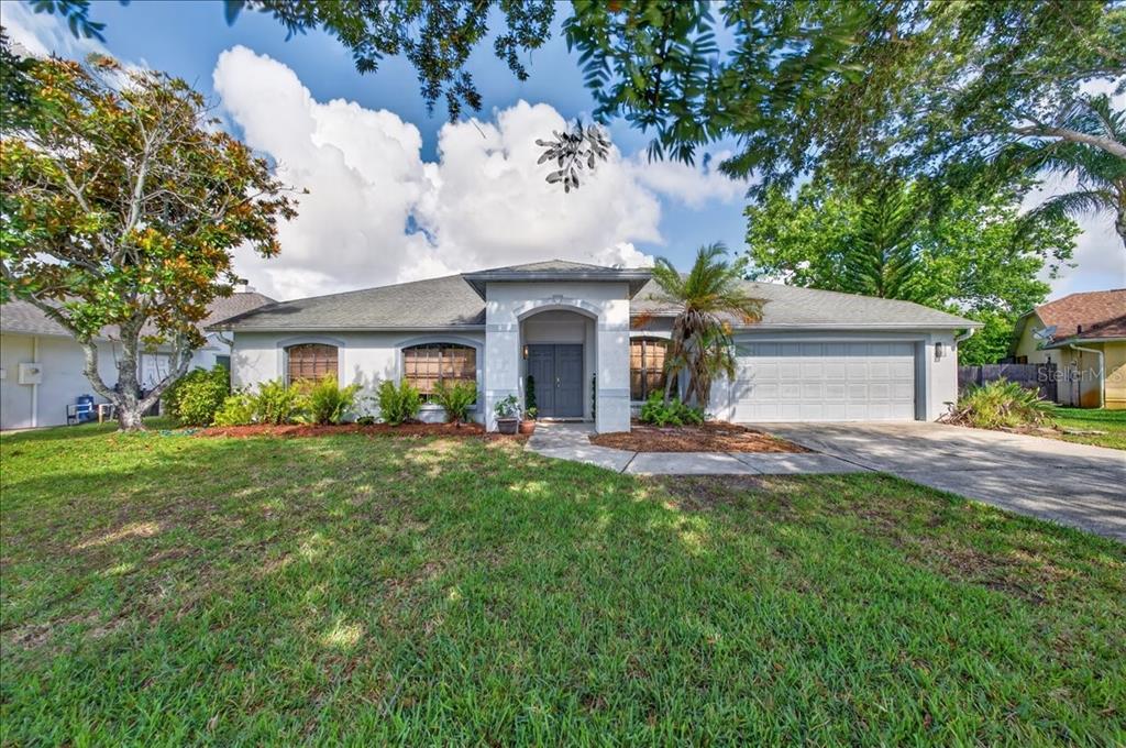 A single-story house with a gray exterior, arched entryway, and a two-car garage — 5068 ALAMANDA DRIVE, MELBOURNE, FL