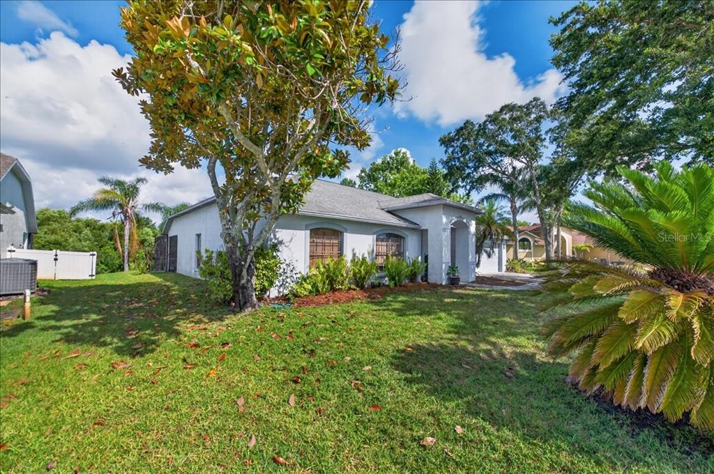 A single-story house with a gray roof and light-colored exterior sits on a grassy lawn — 5068 ALAMANDA DRIVE, MELBOURNE, FL