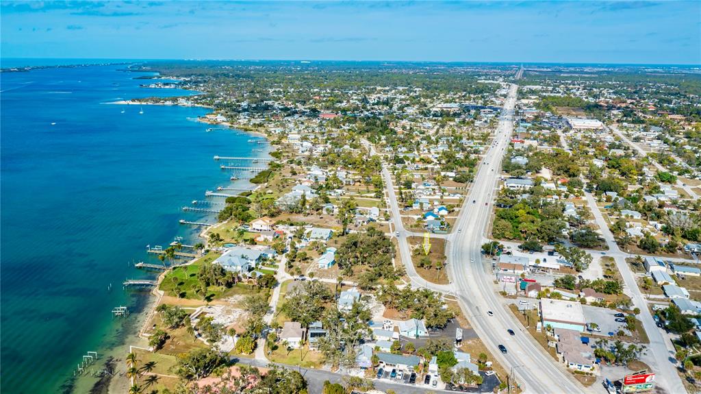 This is an aerial view of a coastal town featuring a vacant lot marked by a yellow arrow — 800 S MCCALL ROAD, ENGLEWOOD, FL