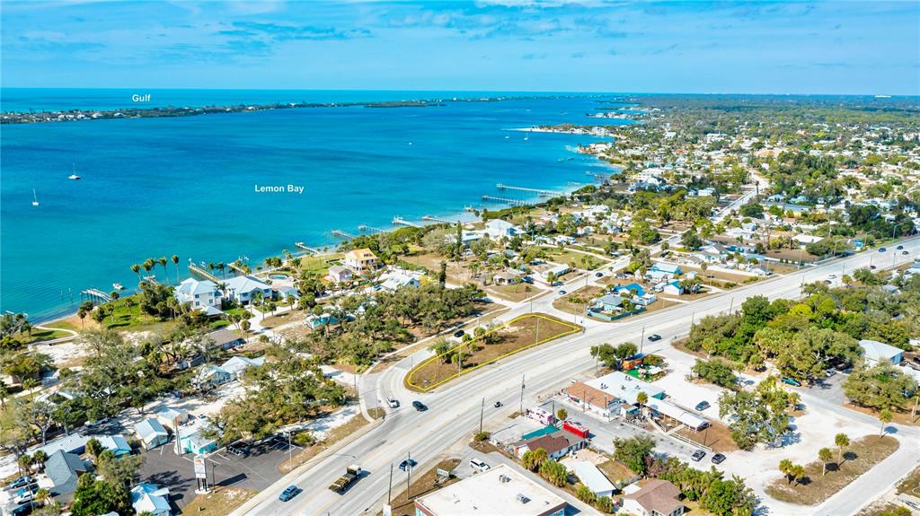 An aerial view shows a vacant, outlined lot situated between a road and Lemon Bay — 800 S MCCALL ROAD, ENGLEWOOD, FL