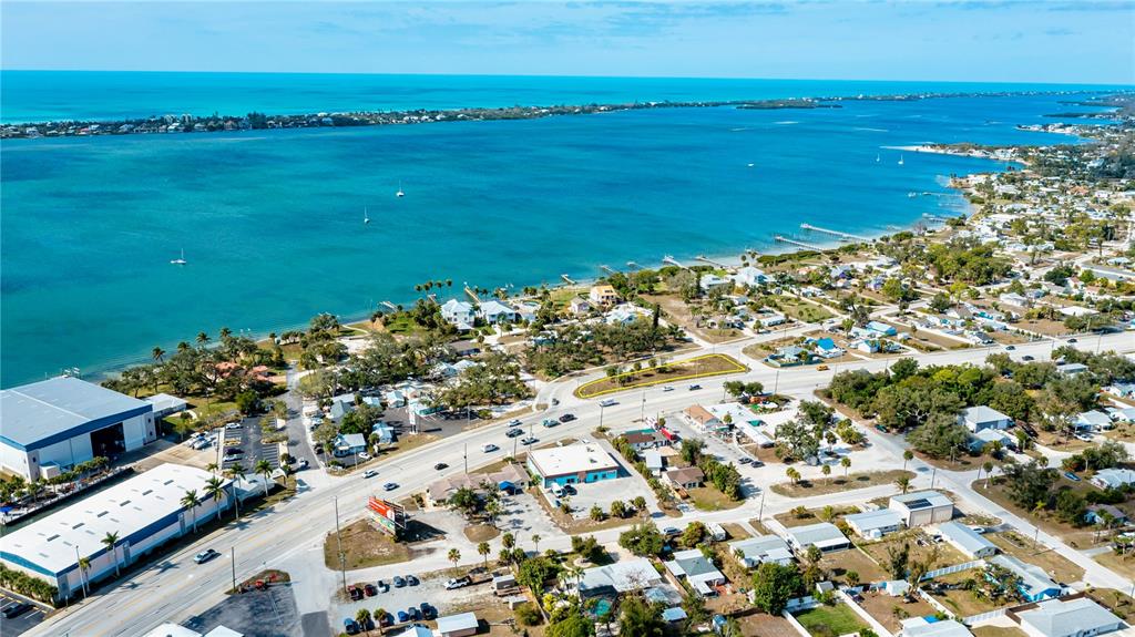 An aerial view shows a coastal town with a highlighted vacant lot near a road — 800 S MCCALL ROAD, ENGLEWOOD, FL