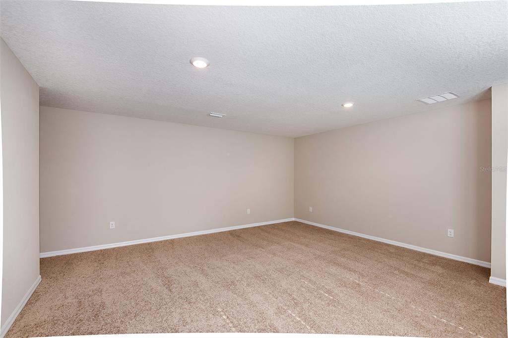 An empty room with beige walls, tan carpeting, and recessed ceiling lighting — 35417 ARBOR RETREAT DRIVE, DADE CITY, FL