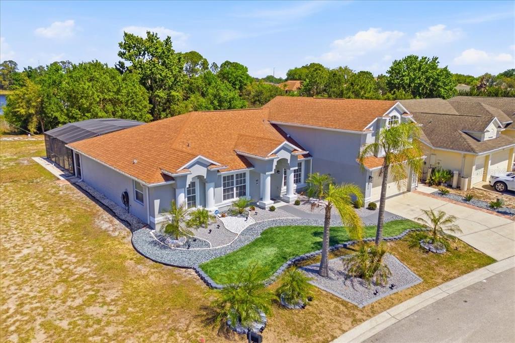 An aerial view of a single-story house with a brown roof and a screened-in pool — 437 GRAND RESERVE DRIVE, DAVENPORT, FL