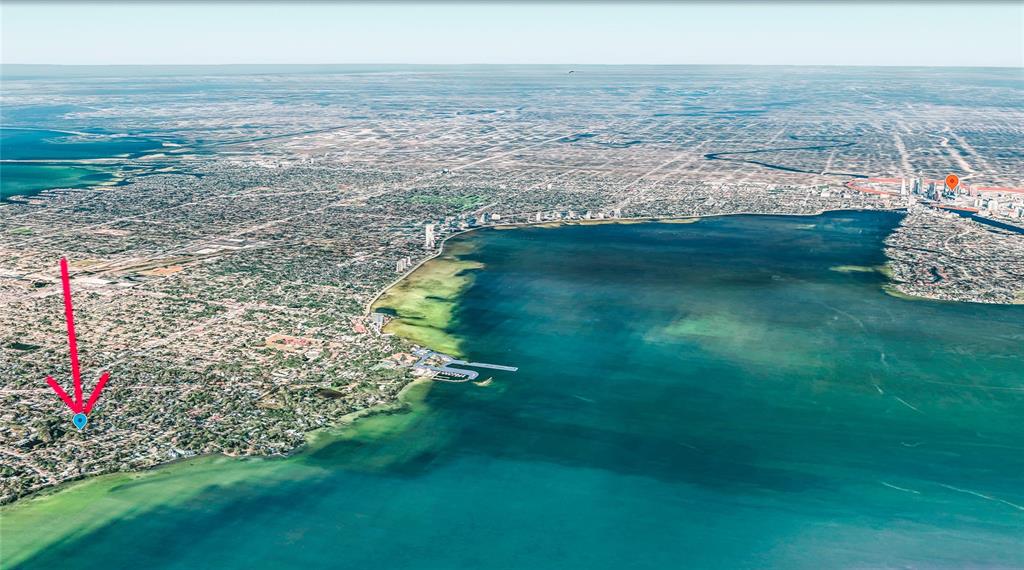 This aerial rendering shows a coastal city with a blue location pin and red arrow — 6213 SANDERS DRIVE, TAMPA, FL