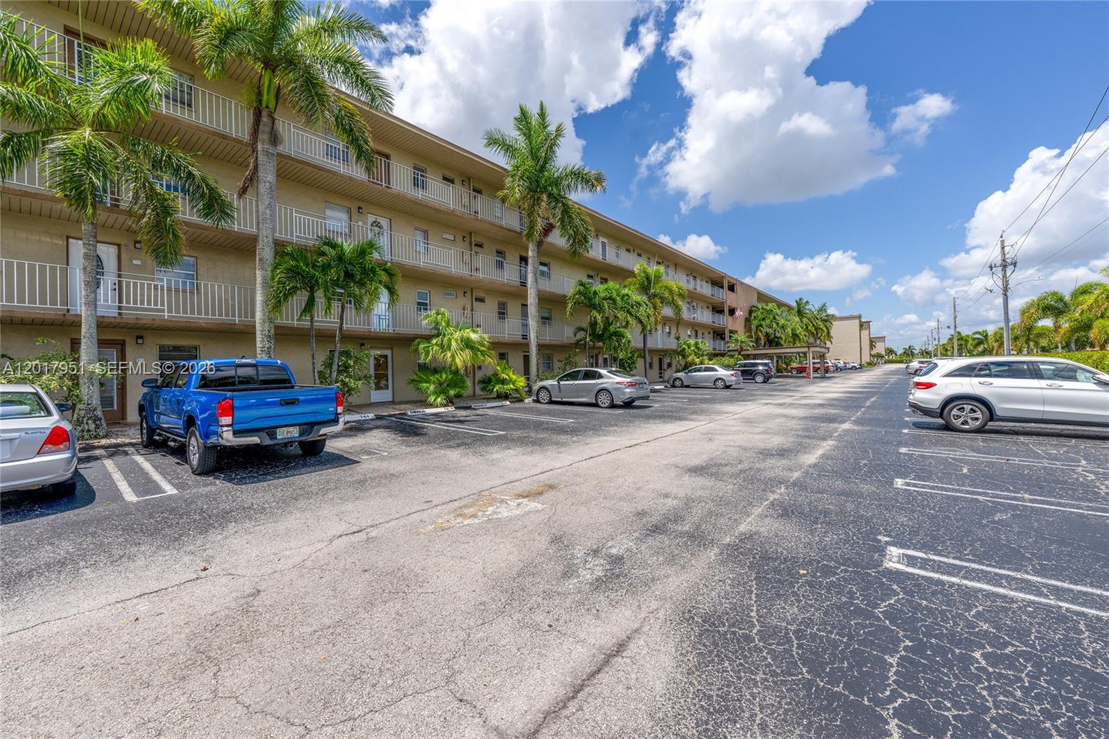 A multi-story apartment building with a parking lot and palm trees in front — 330 NE 26th Ave # 1120, Boynton Beach FL 33435, BOYNTON BEACH, FL