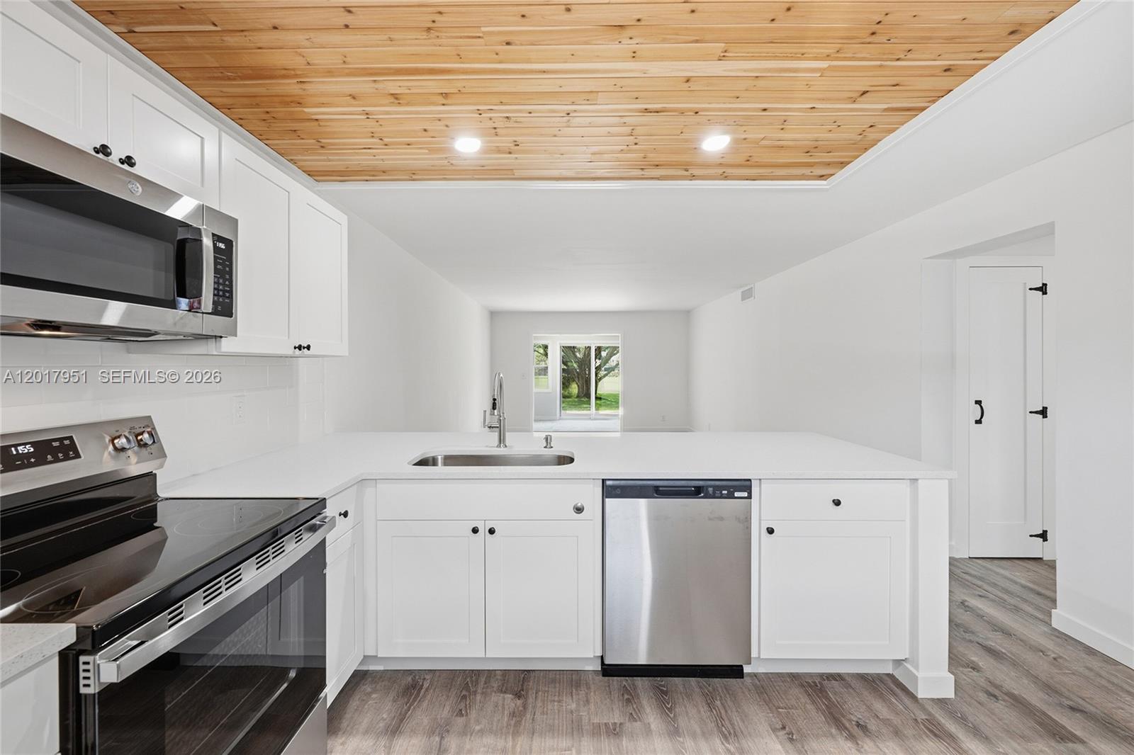 A modern kitchen features white cabinets, stainless steel appliances, and a wood-paneled ceiling — 330 NE 26th Ave # 1120, Boynton Beach FL 33435, BOYNTON BEACH, FL