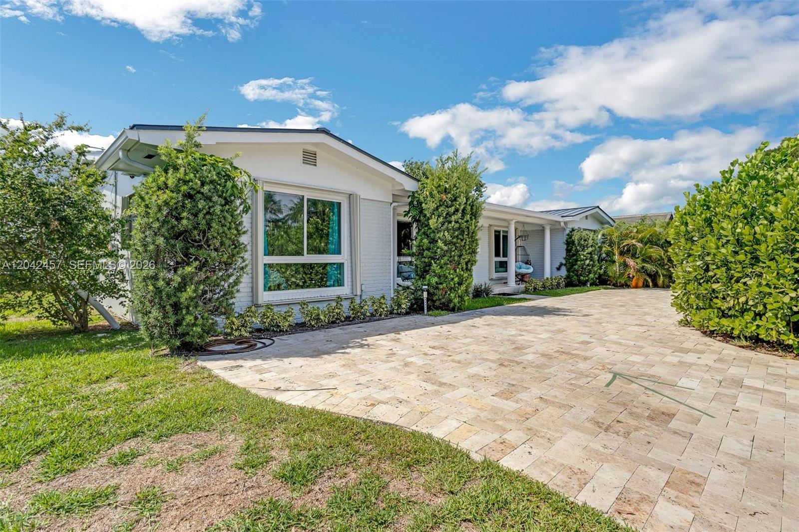 A single-story house with a light-colored brick facade and a paved driveway — 633 N Crescent Dr, Hollywood FL 33021, HOLLYWOOD, FL
