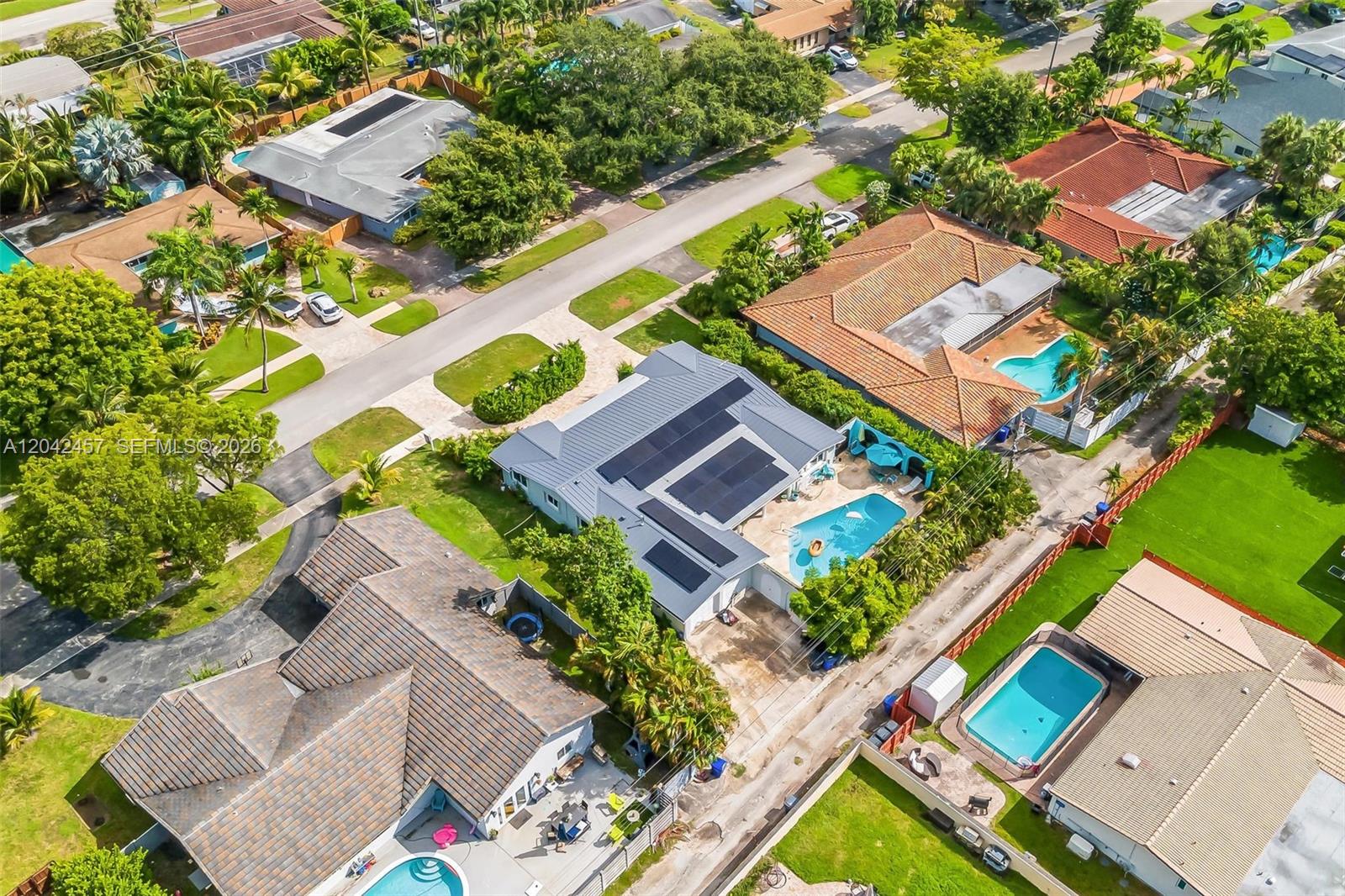 An aerial view shows several residential houses with swimming pools and solar panels on roofs — 633 N Crescent Dr, Hollywood FL 33021, HOLLYWOOD, FL