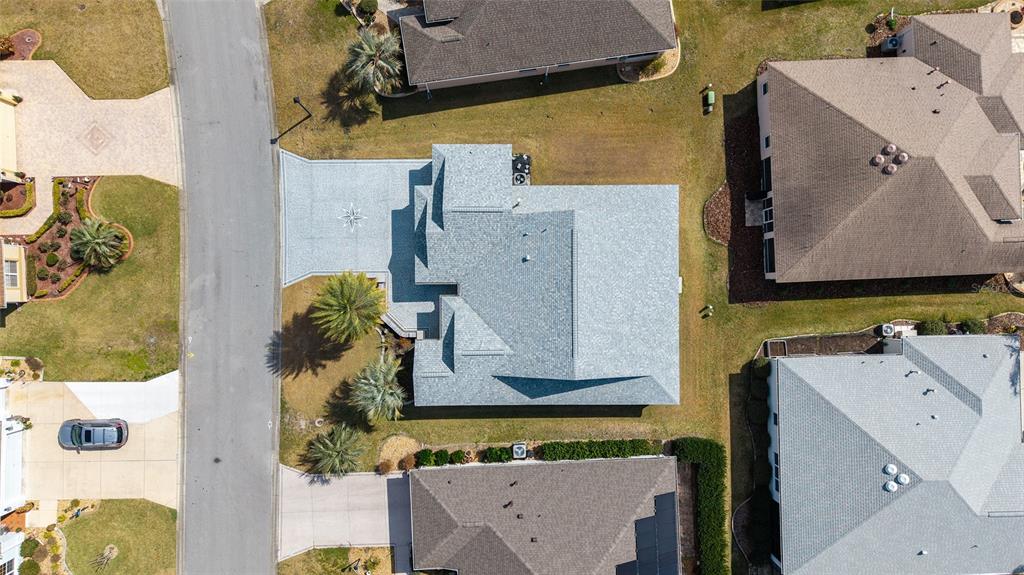 An aerial view shows a residential house with a gray roof and surrounding properties — 840 FOLSUM PLACE, THE VILLAGES, FL