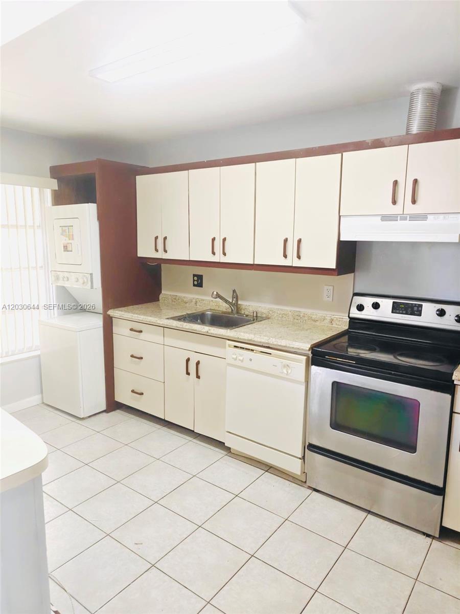A kitchen features white cabinets, a stainless steel stove, a dishwasher, and tiled flooring — 1140 NW 85th Ave, Plantation FL 33322, PLANTATION, FL