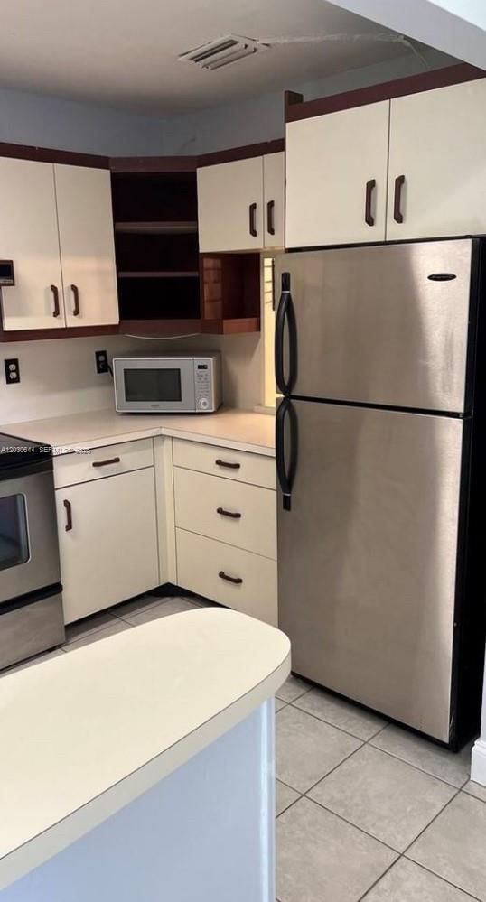 A kitchen features white cabinets, stainless steel appliances, and a light-colored countertop — 1140 NW 85th Ave, Plantation FL 33322, PLANTATION, FL