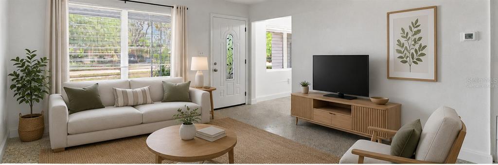 A bright living room features a white sofa, wooden coffee table, and television console — 7204 ASTOR DRIVE, NEW PORT RICHEY, FL