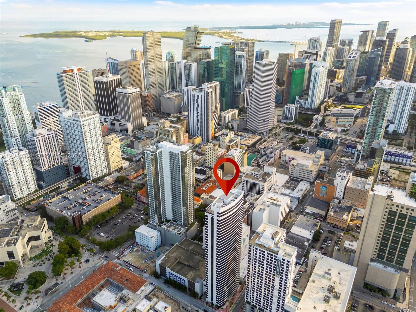 An aerial view of a high-rise building in a dense urban cityscape near the water — 225 N Miami Ave # 1102, Miami FL 33128, MIAMI, FL