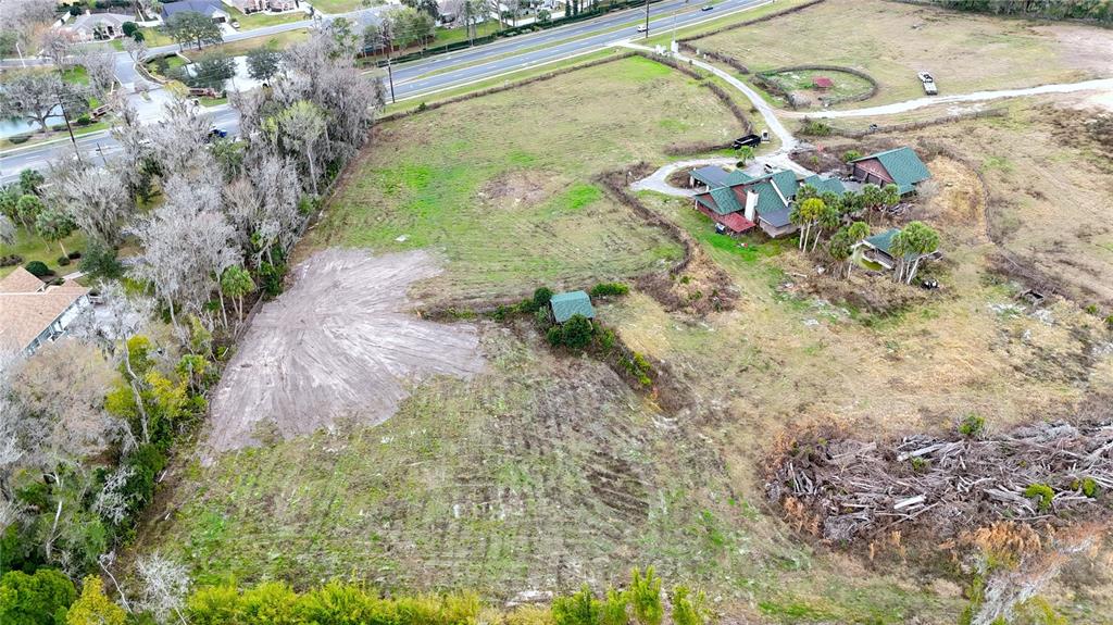 An aerial view shows a large grassy lot with a house, outbuildings, and cleared land — 1195 SW 42ND STREET, OCALA, FL