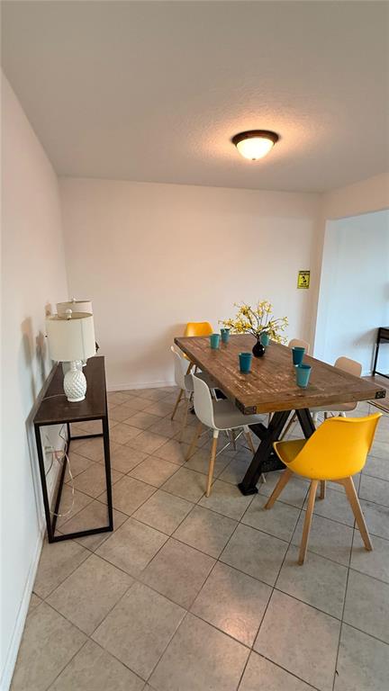 A dining room features a wooden table, yellow and white chairs, and a console table — 227 ORCHID DRIVE, DAVENPORT, FL