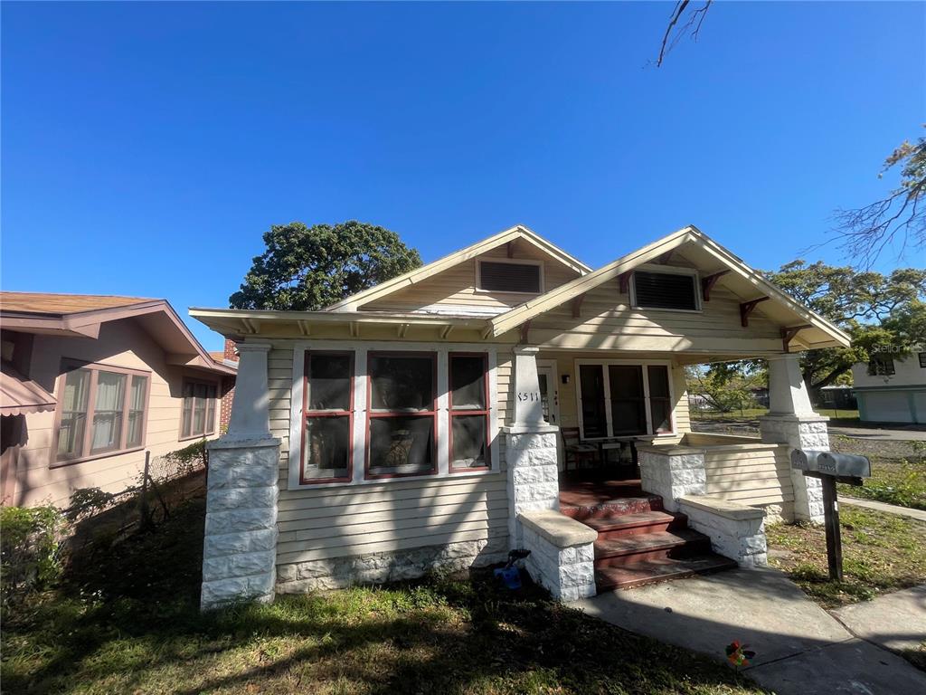A single-story house with light-colored siding, a front porch, and stone-accented columns — 1511 19TH AVENUE S, ST PETERSBURG, FL
