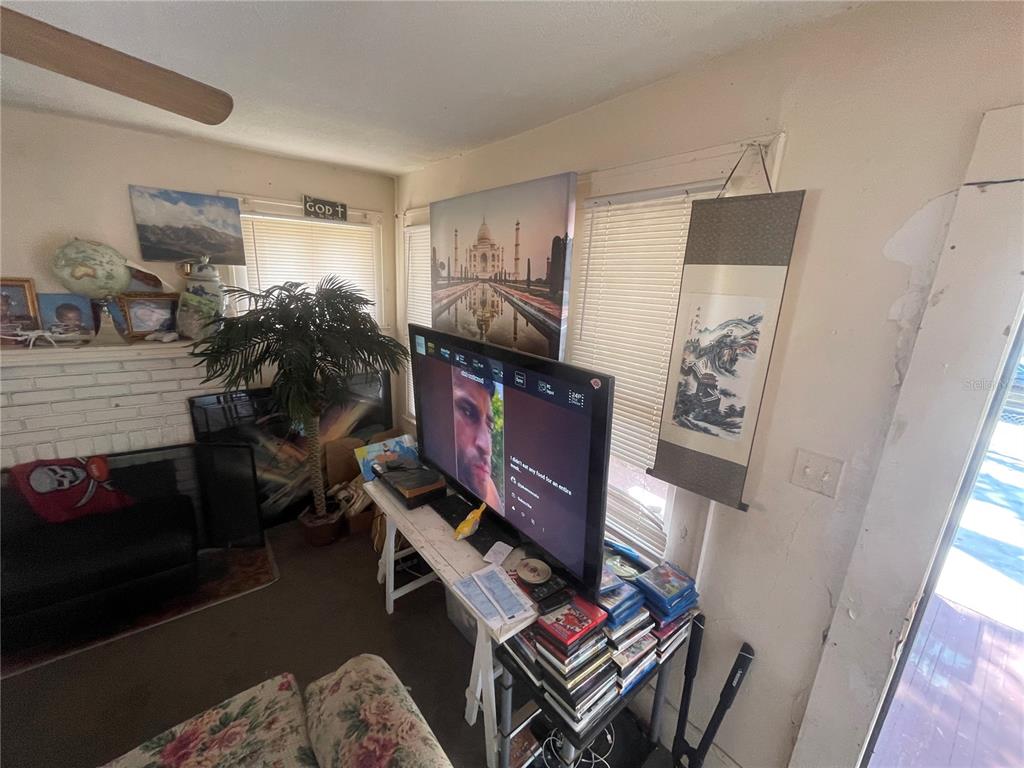 A living room features a television on a stand, a fireplace, and wall art — 1511 19TH AVENUE S, ST PETERSBURG, FL