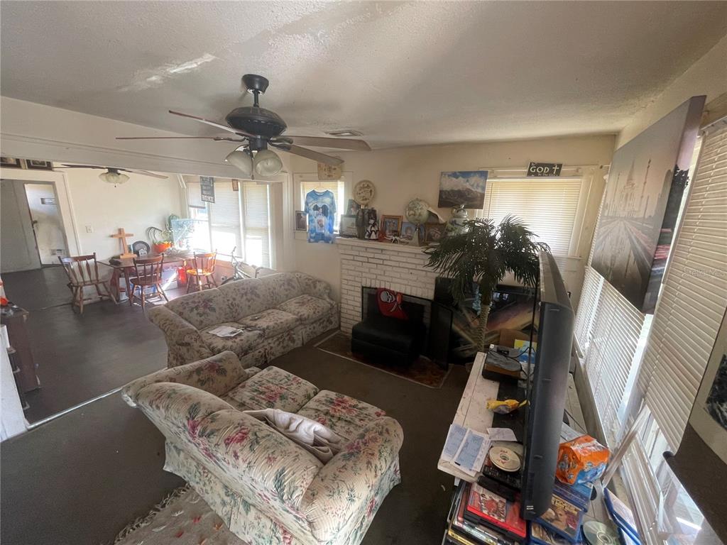 A living room features floral sofas, a white brick fireplace, and a ceiling fan — 1511 19TH AVENUE S, ST PETERSBURG, FL