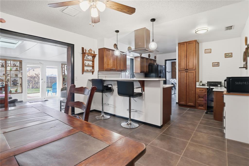 A kitchen with wood cabinets, a breakfast bar with stools, and tile flooring — 1307 ORTEGA STREET, WINTER SPRINGS, FL