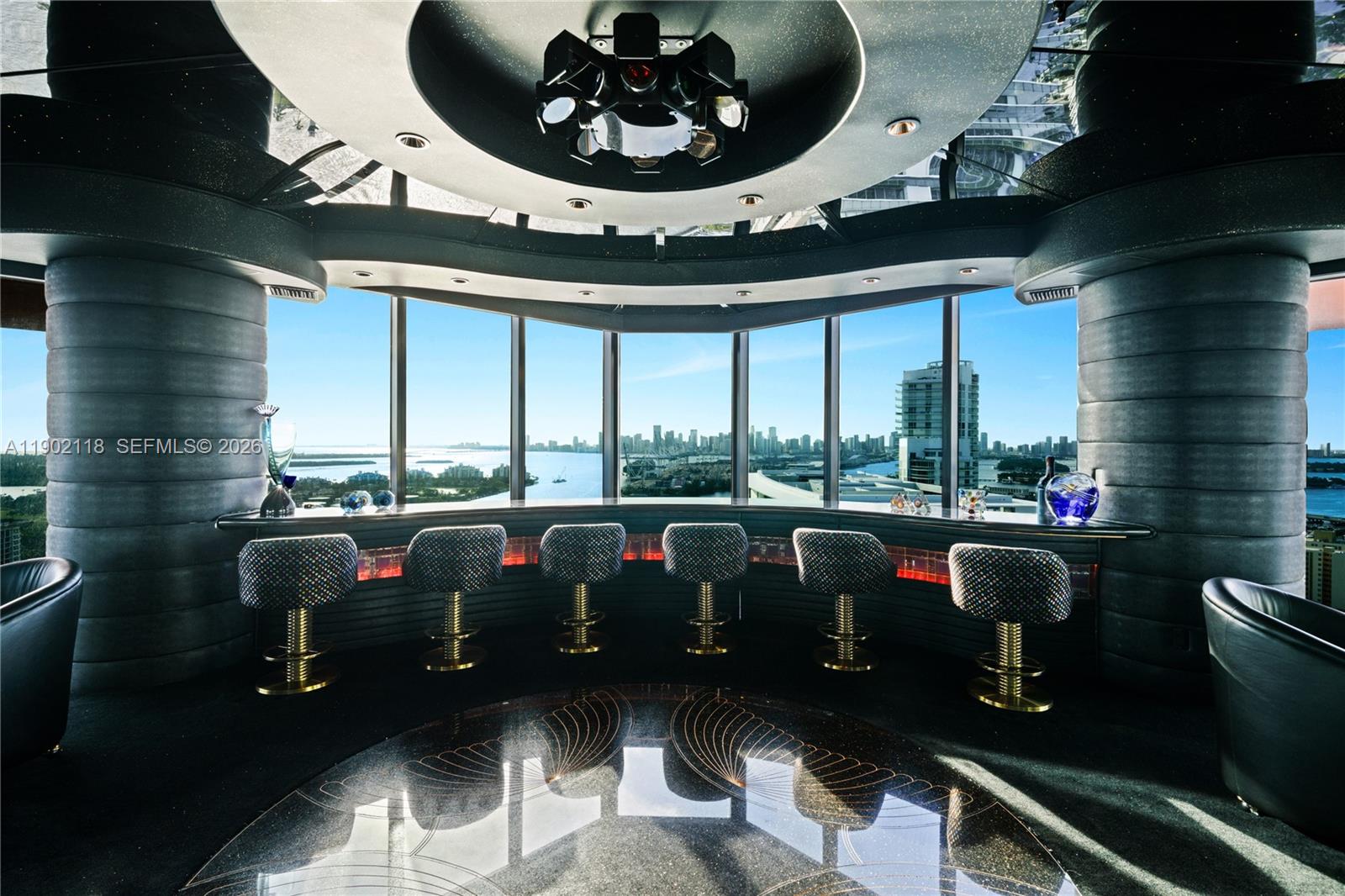 A circular bar area features six stools, a dark ceiling fixture, and panoramic city views — 300 S Pointe Dr # 3103, Miami Beach FL 33139, MIAMI BEACH, FL