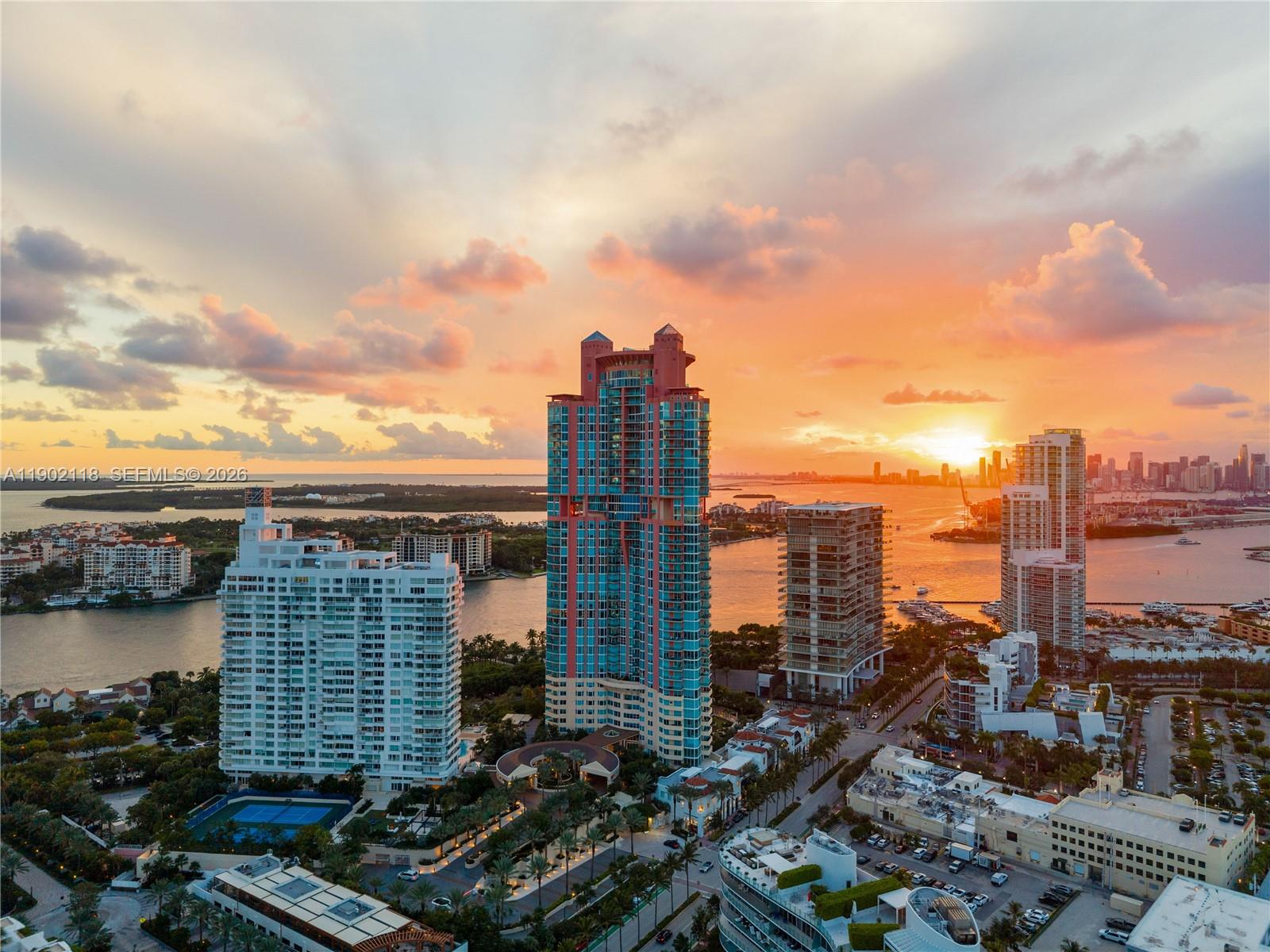 An aerial view shows high-rise residential buildings along a waterfront at sunset — 300 S Pointe Dr # 3103, Miami Beach FL 33139, MIAMI BEACH, FL