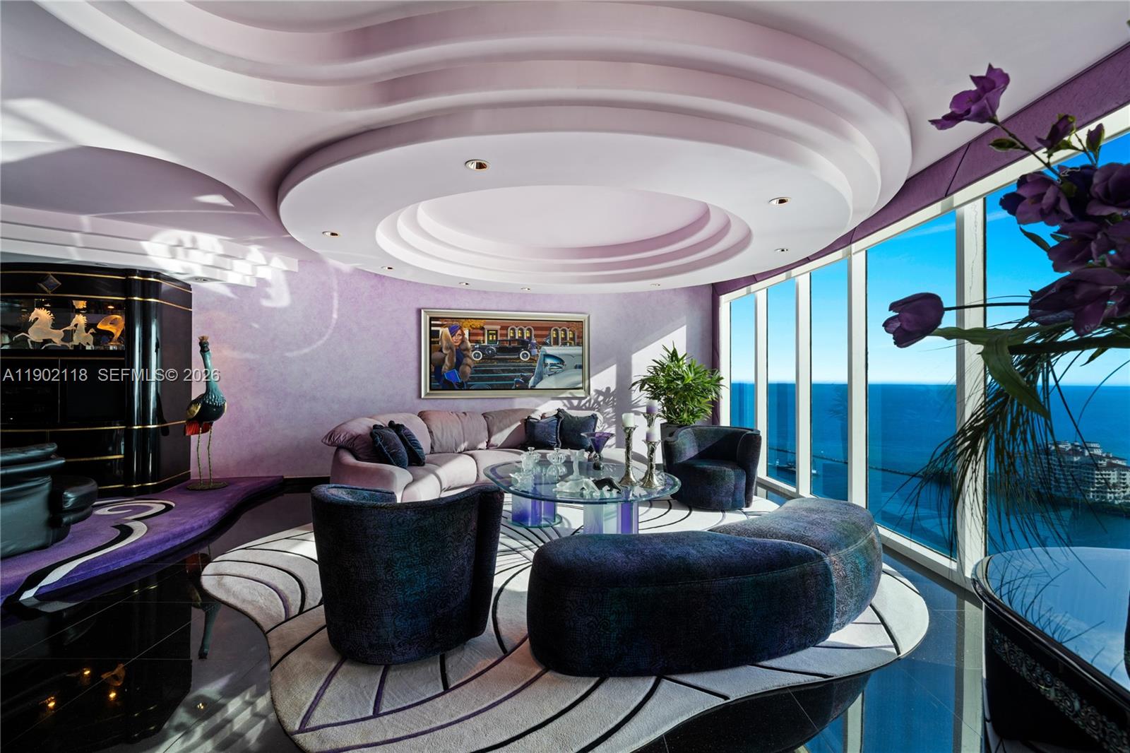 A living room with purple walls, a circular tray ceiling, and floor-to-ceiling ocean views — 300 S Pointe Dr # 3103, Miami Beach FL 33139, MIAMI BEACH, FL
