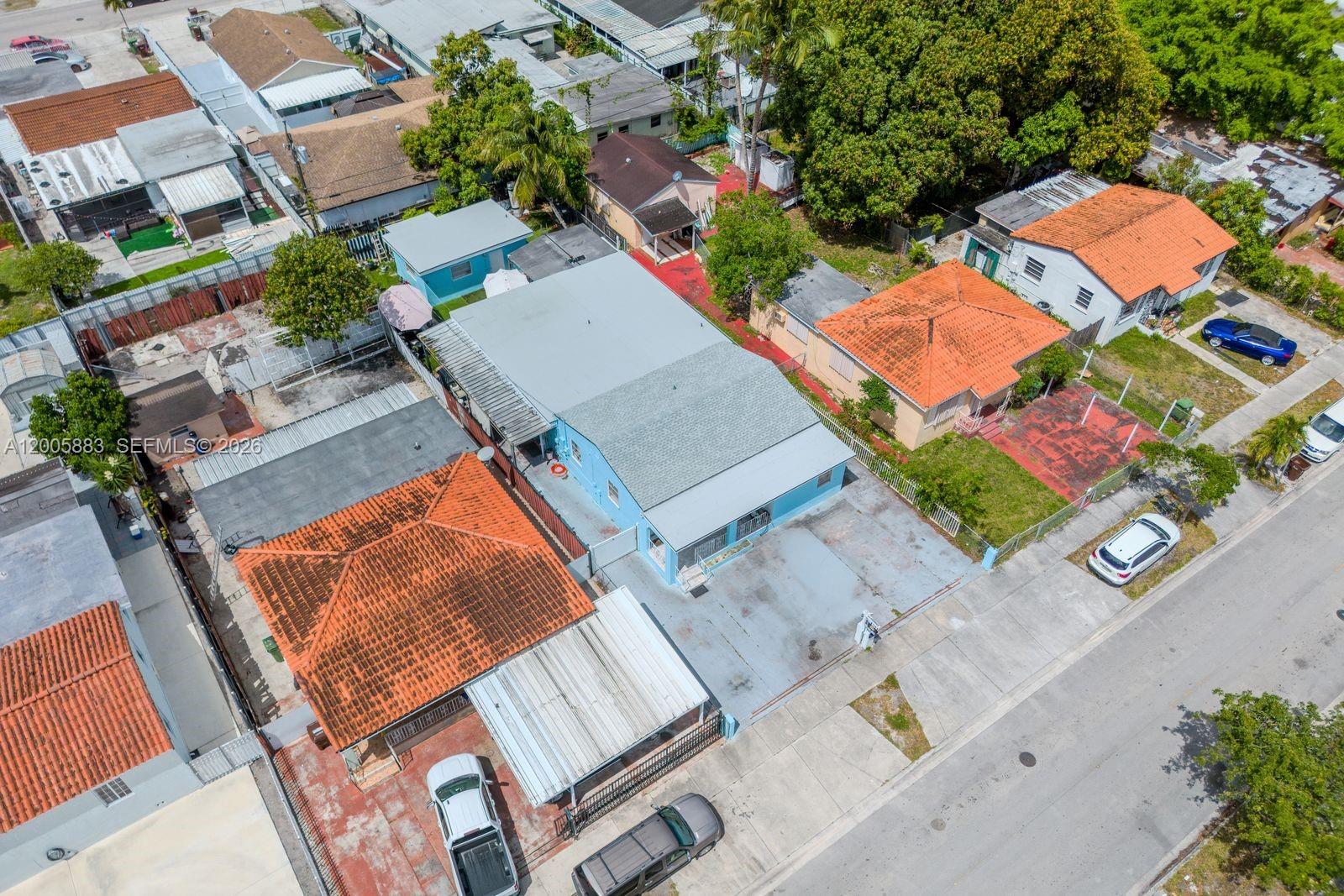 An aerial view shows several houses with orange tile roofs and a light blue building — 141 E 16th St, Hialeah FL 33010, HIALEAH, FL