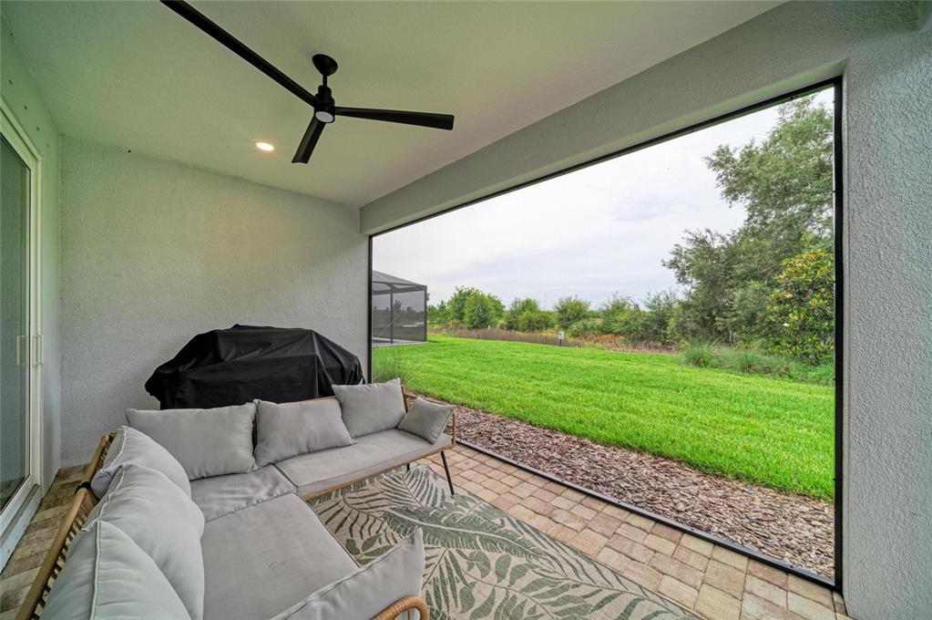 A covered patio features a sectional sofa, a ceiling fan, and a large screened opening — 1079 WATERLINE COURT, SARASOTA, FL