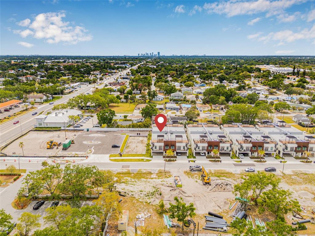 An aerial view shows a row of modern townhouses with rooftop decks near a construction site — 460 87TH AVENUE NORTH, ST PETERSBURG, FL