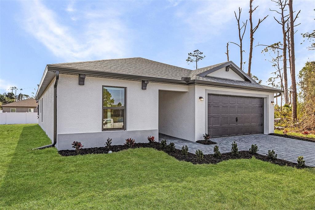 A single-story house with a white stucco exterior, a gray roof, and a paved driveway — 5830 BABIAN ROAD, NORTH PORT, FL