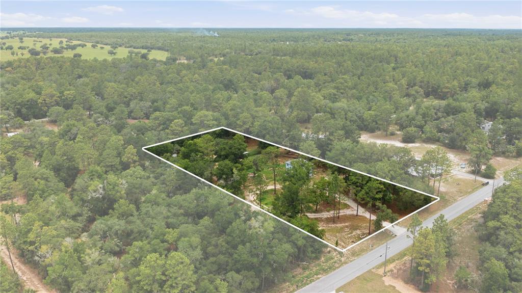 An aerial view shows a rectangular lot with a house surrounded by dense forest — 6870 SW 206TH AVENUE, DUNNELLON, FL