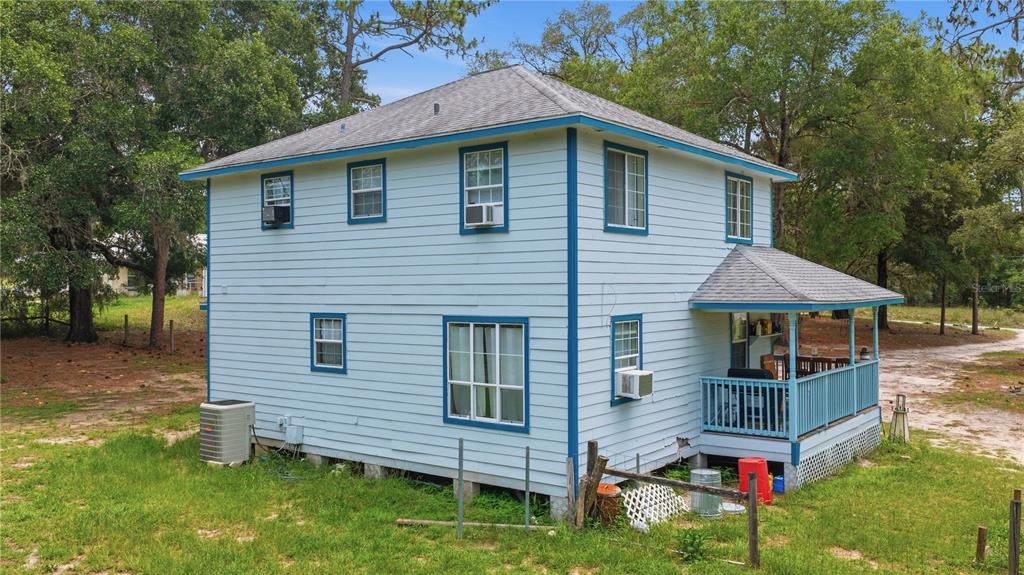 A two-story light blue house with blue trim and a small covered porch — 6870 SW 206TH AVENUE, DUNNELLON, FL