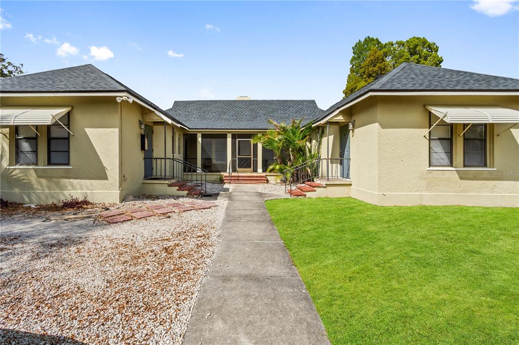 A single-story house with a U-shaped layout, a central walkway, and a gravel driveway — 315 RIDGE MANOR DRIVE, LAKE WALES, FL