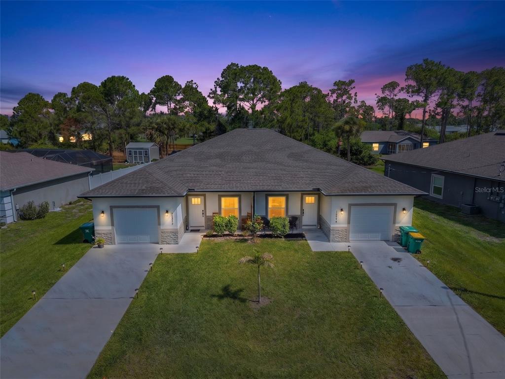 An aerial view of a duplex home with two garages and a shared front lawn — 12552 BUFFING ROAD, PORT CHARLOTTE, FL