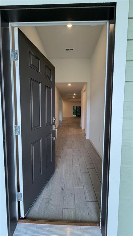 An open front door reveals a hallway with wood-look tile flooring and recessed lighting — 19725 SW 79TH PLACE, DUNNELLON, FL