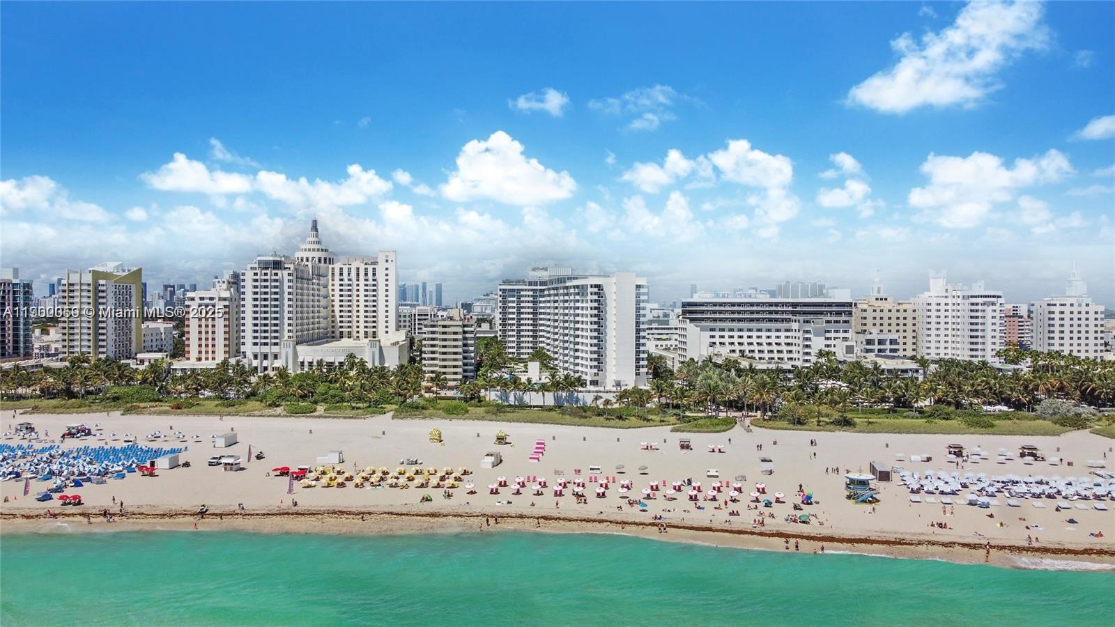 An aerial view of a sandy beach with umbrellas and hotels in the background — 100 Lincoln Rd # 607, Miami Beach FL 33139, MIAMI BEACH, FL