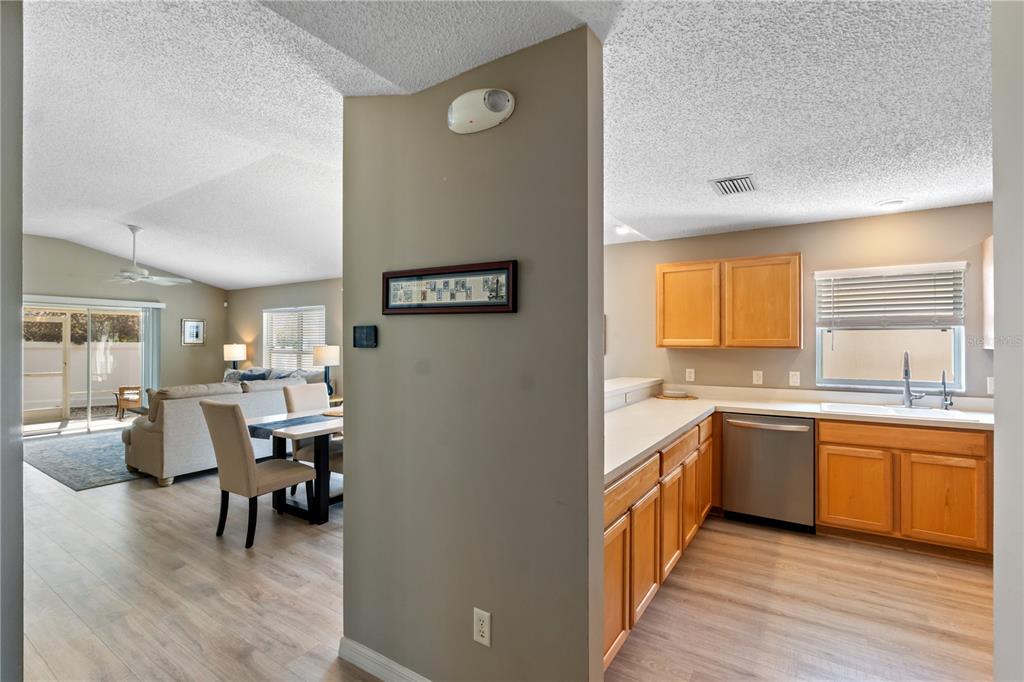 A view from a kitchen looking into an open-concept dining and living area — 1666 SUMMERCHASE LOOP, THE VILLAGES, FL