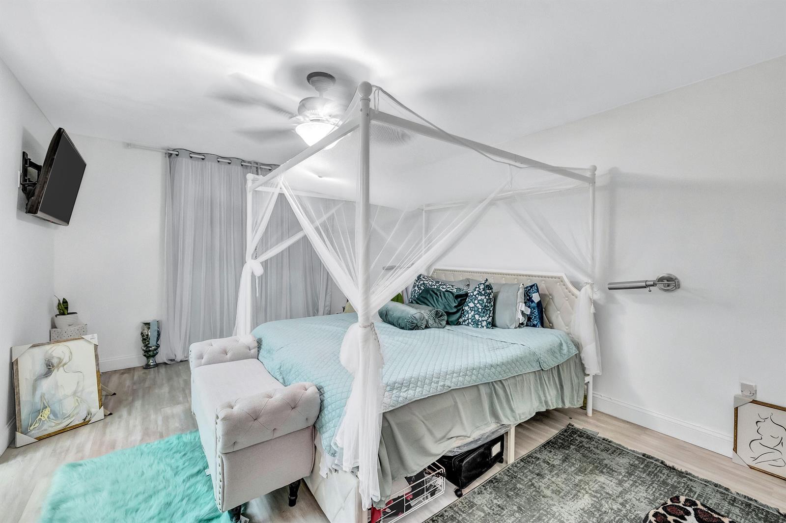 A bedroom features a white canopy bed with light blue bedding and a tufted bench — 6137 Rainbow Circle, FL 33463, FL